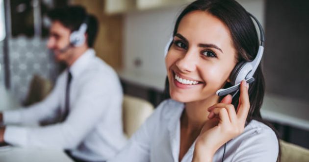 How can I help you? Beautiful call center workers in headphones are working at modern office.